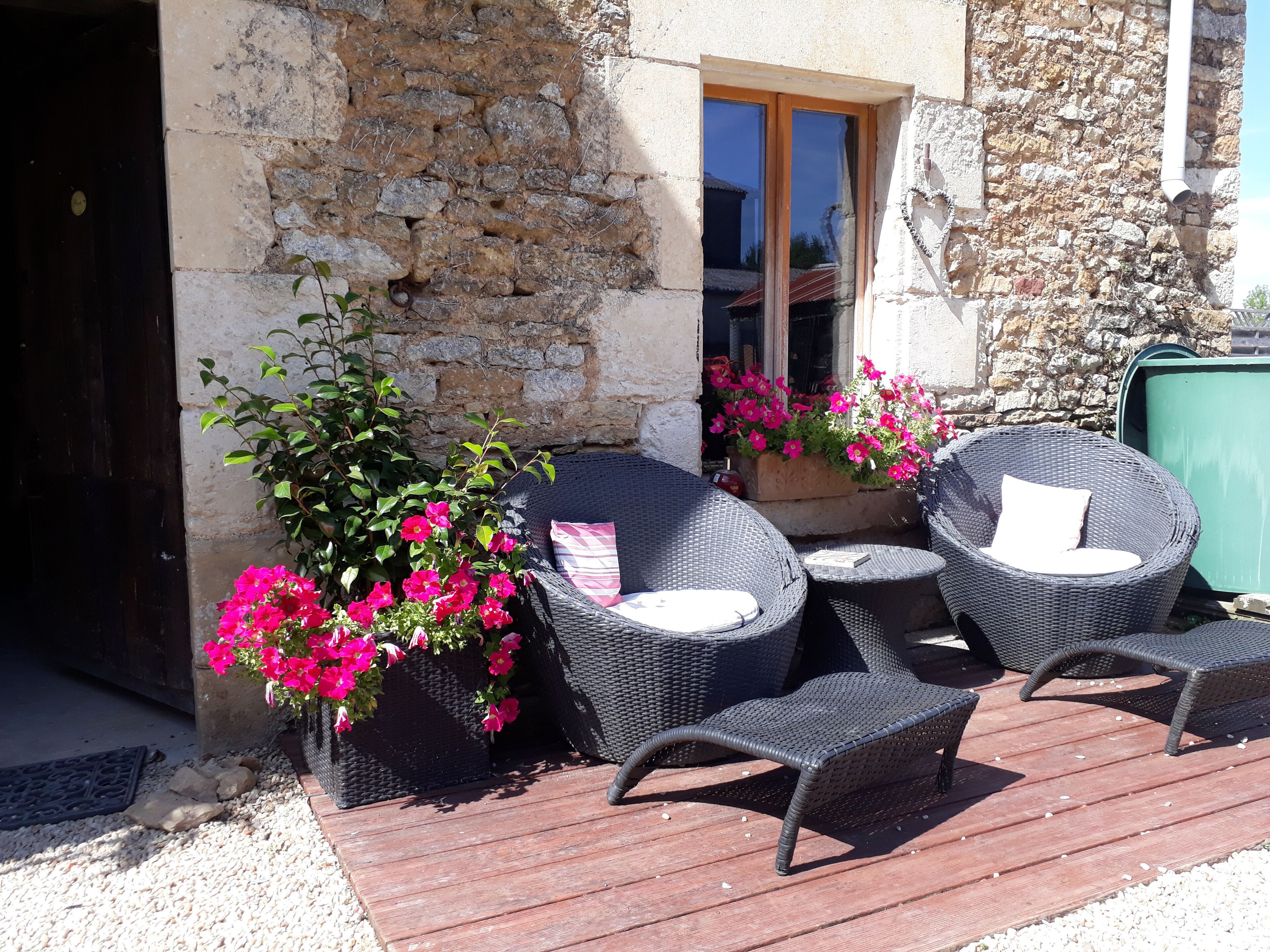 An outdoor seating area with wicker furniture and potted plants.
