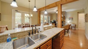 A kitchen with granite countertops, stainless steel sink, wooden cabinets, and pendant lighting. - Condo w/ Pool & Beach Access in Bear Lake Reserve! (Tuckasegee)