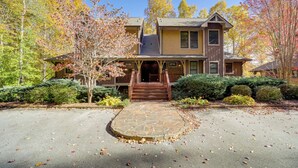 A two-story house with a stone entryway, surrounded by autumn foliage and a clear sky. - Condo w/ Pool & Beach Access in Bear Lake Reserve! (Tuckasegee)