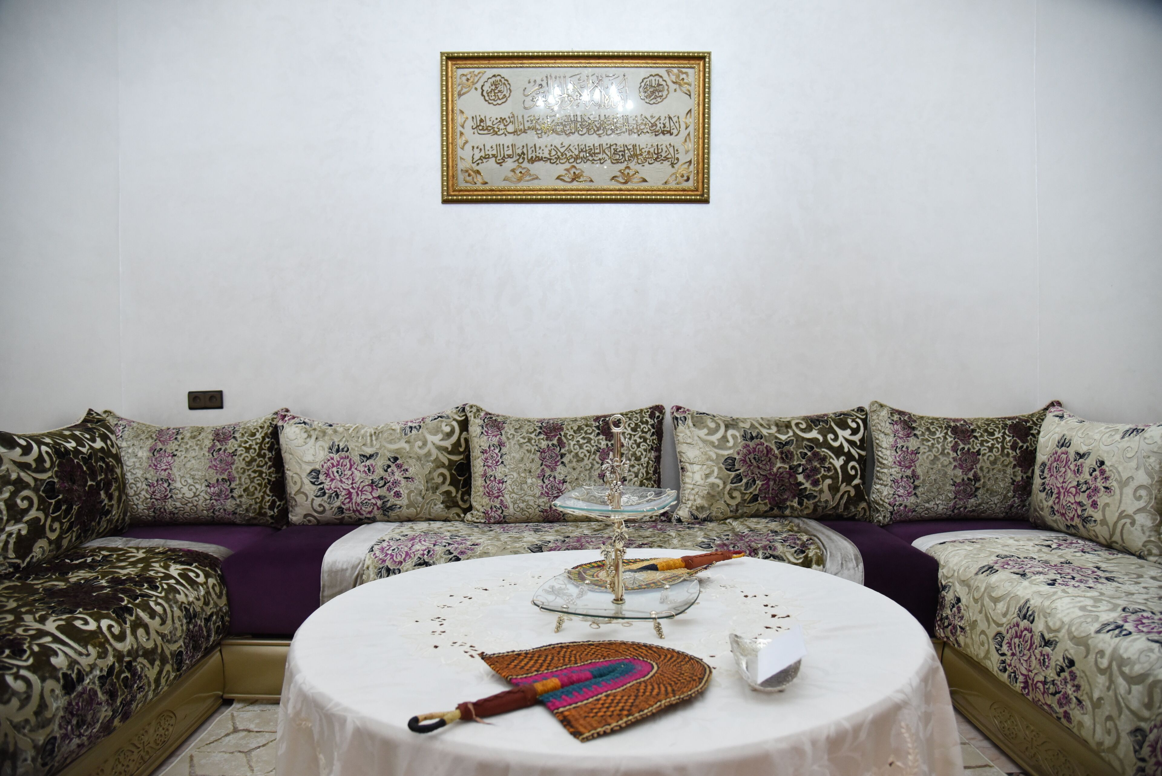 Ein Wohnzimmer mit einer Couch, einem runden Tisch und einer Wanddekoration.