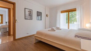 Ein Hotelzimmer mit Bett, Schreibtisch und einem fenster mit Vorhängen.