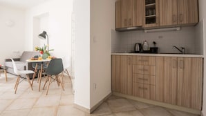 A modern kitchen with wooden cabinets, a countertop, and a dining area with a table and chairs.