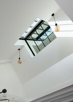Um claraboia com design moderno, duas lâmpadas pendentes e teto branco.