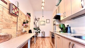 Eine Küche mit Holzausstattung, einer langen Arbeitsplatte und einer Pendelleuchte.