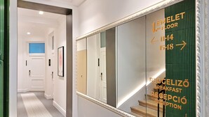 A hotel reception area with directional signs to the breakfast area and reception.