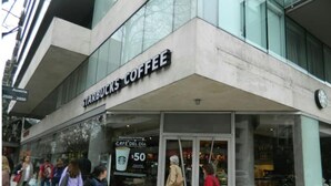 Starbucks-kahvila, jossa on lasijulkisivu ja kyltti, jossa mainostetaan 50 dollarin arvoista tarjousta.