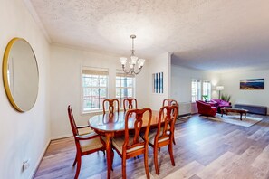 A dining area with a wooden table and chairs, a chandelier, and a large mirror on the wall. - Comfortable home with gas fireplace, less than a mile to Sugar Mountain (Sugar Mountain)