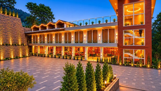 A modern hotel with multiple floors, outdoor seating, and a well-lit facade.