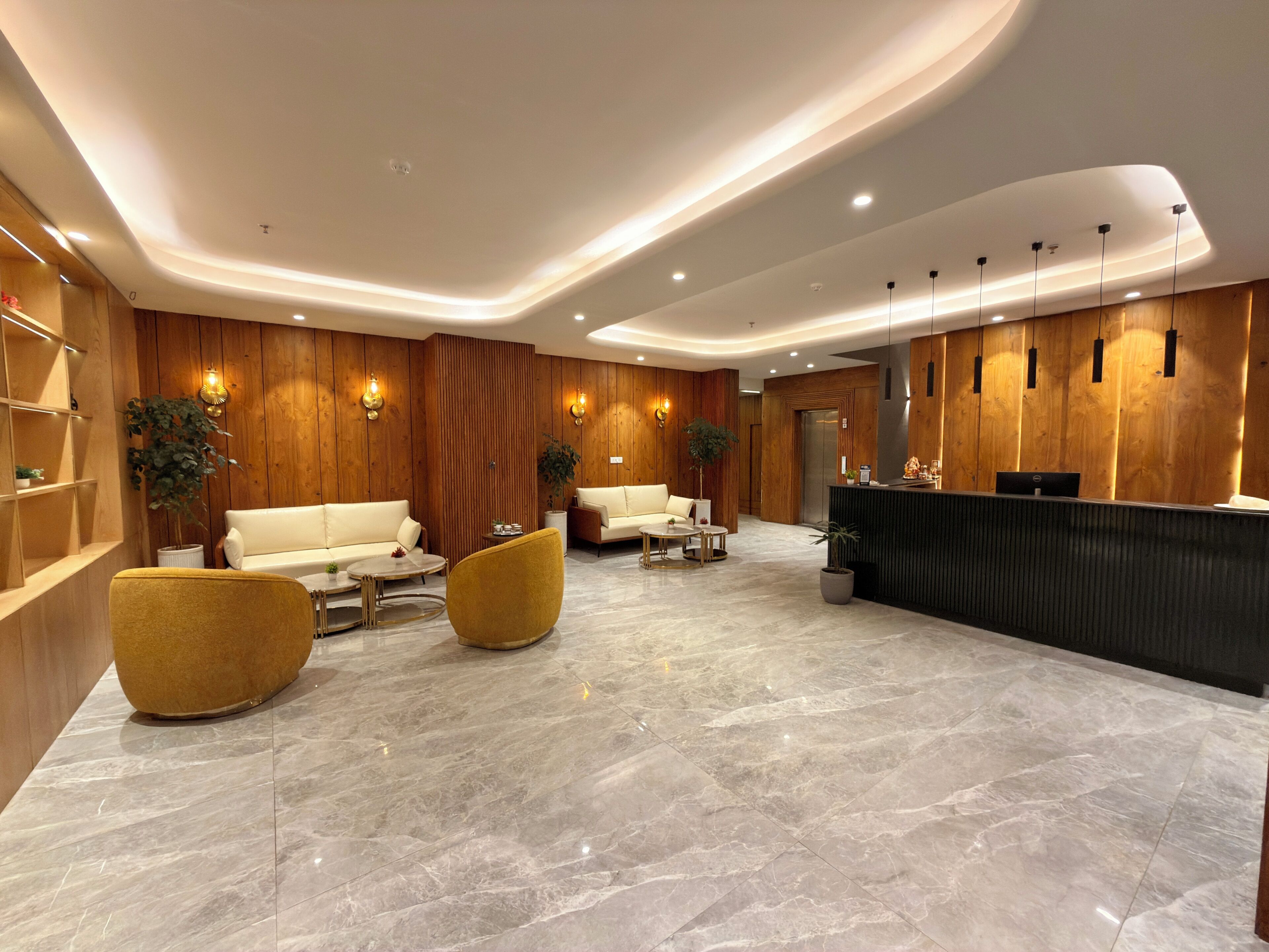 A modern lobby with a reception desk, two sofas, and a coffee table.