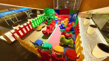 A children's play area with various colorful play structures, including a slide and a ball pit.