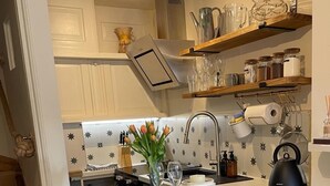 A kitchen with a blue island, white cabinets, and a star-patterned backsplash.
