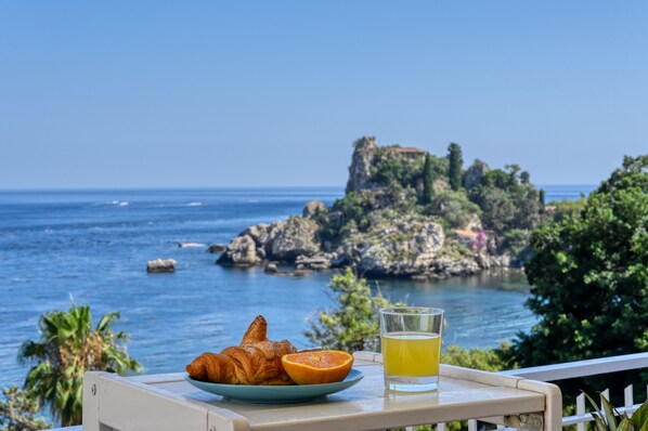 Guests can enjoy a serene dining experience with a view of the ocean from this seaside table setting.
