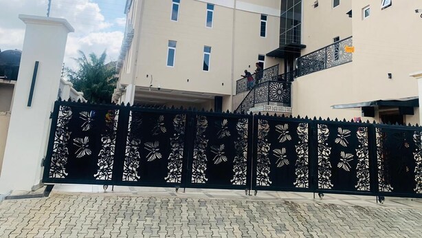 Un hotel con un letrero que dice "Palazzo Resort Hotel", un acceso con portón y una escalera que conduce a la entrada.