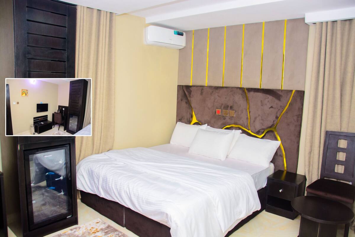 Une chambre d’hôtel équipée d’un lit, de tables de chevet, d’un téléviseur et d’un appareil de climatisation.