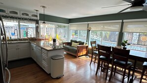 Una cocina amplia con comedor, ventanas grandes y un ventilador de techo.