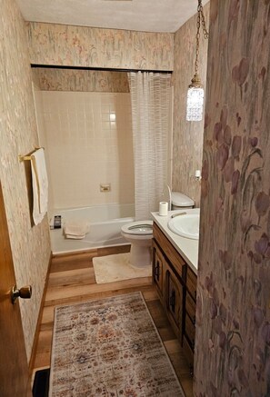 Une salle de bain avec une baignoire, des toilettes et un lavabo.