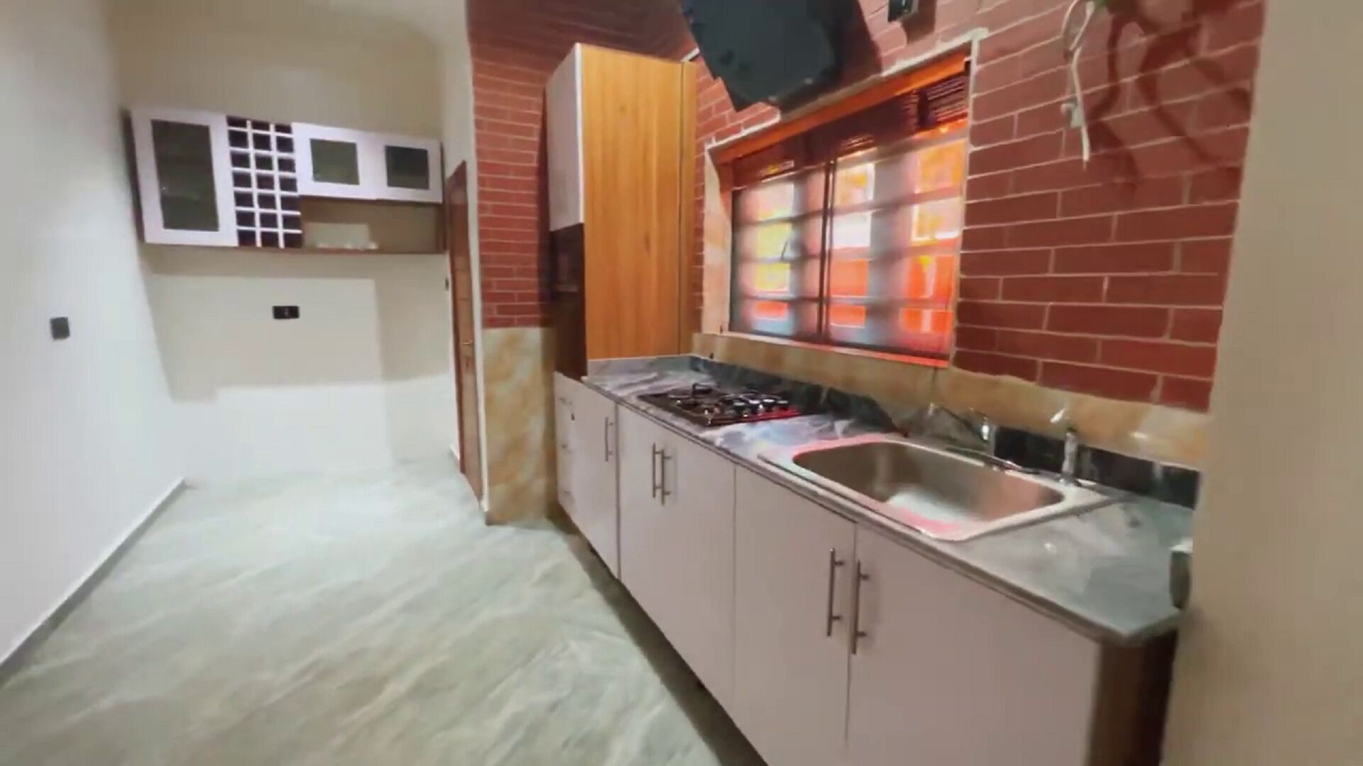 Una cocina con estufa a gas, lavaplatos y un microondas sobre la encimera.