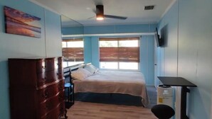 A bedroom with a bed, a dresser, a chair, a TV, and a window. - Large 4bd 2bth pool home with hot tub, waterfall feature and private back yard! (Palm Bay)