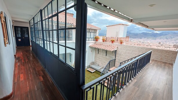 Un balcon offrant une vue sur la ville et les montagnes.