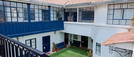 A multi-story building with a courtyard, a staircase, and a balcony with a railing.