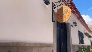 Un bâtiment à la façade blanche, au toit recouvert de tuiles rouges, et sur lequel on peut lire une enseigne indiquant qu’il s’agit d’un restaurant.