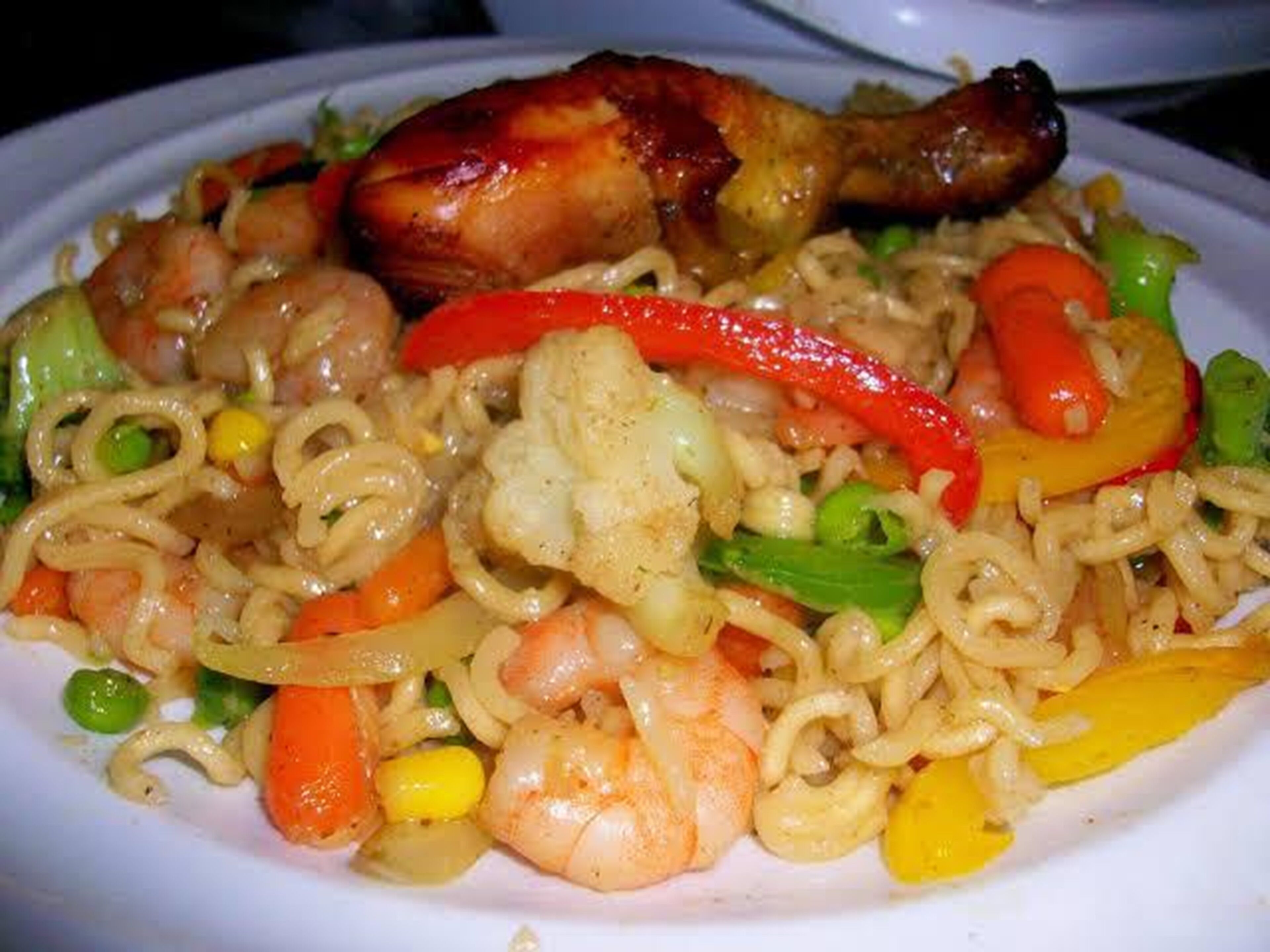 A plate of stir-fried noodles with vegetables and shrimp.