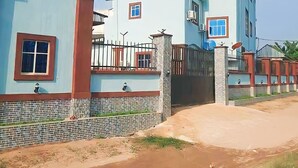 A two-story residential building with a tiled exterior and a gated entrance. - BeamGate Hotel (Uyo)