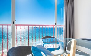 Enjoy the breathtaking sea views from this room's spacious balcony with a glass partition and comfortable seating for two.