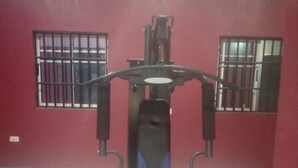 A gym with a stationary bike, a bench press, and a squat rack.