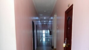 A long, narrow hallway with a shiny floor, leading to a door at the end.