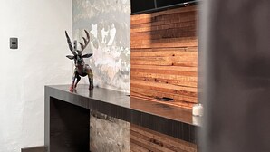 A modern interior with a wooden accent wall, a decorative deer sculpture, and a minimalist design. - Beautiful studio in Jalatlaco, a beautiful neighborhood (Oaxaca de Juárez)