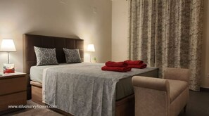 Relax in this inviting space with a comfortable bed, a chair, and a nightstand with a lamp.