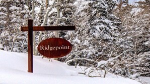 Un senyal de fusta amb el nom 'Ridgepoint' en un paisatge nevats.