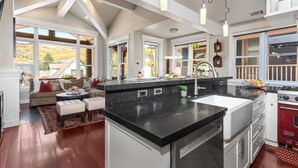 A spacious kitchen with a large island, a dining area with a sofa, and a view of the outdoors. - Red Crest 3 Bedrooms PWS-957 by KBM (Park City)