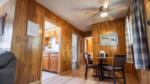 A wooden interior with a dining area, kitchen, and a ceiling fan. - Cottage #3 Snow Day, 2 Bedroom Cottage (Lake City)