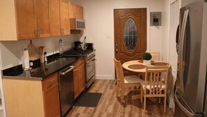 Une cuisine de taille réduite, dotée de meubles de rangement en bois, d’une cuisinière, d’un évier et d’un réfrigérateur.