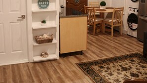 Une cuisine compacte avec des meubles en bois, un coin repas comprenant une table et des chaises, et un lave-linge encastré.