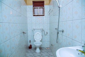 A bathroom with a toilet, a shower, and a sink. - Beautiful 2-bed House in Kampala (Kampala)