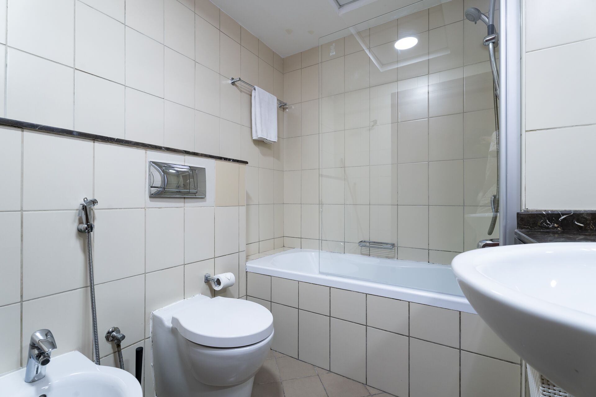 A modern bathroom with a toilet, sink, and shower area.