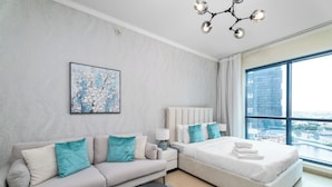 A modern bedroom with a large window, a sofa, a bed, and a ceiling light fixture. - Nasma Holiday Homes - Jumeirah Bay X1 To (Dubai)