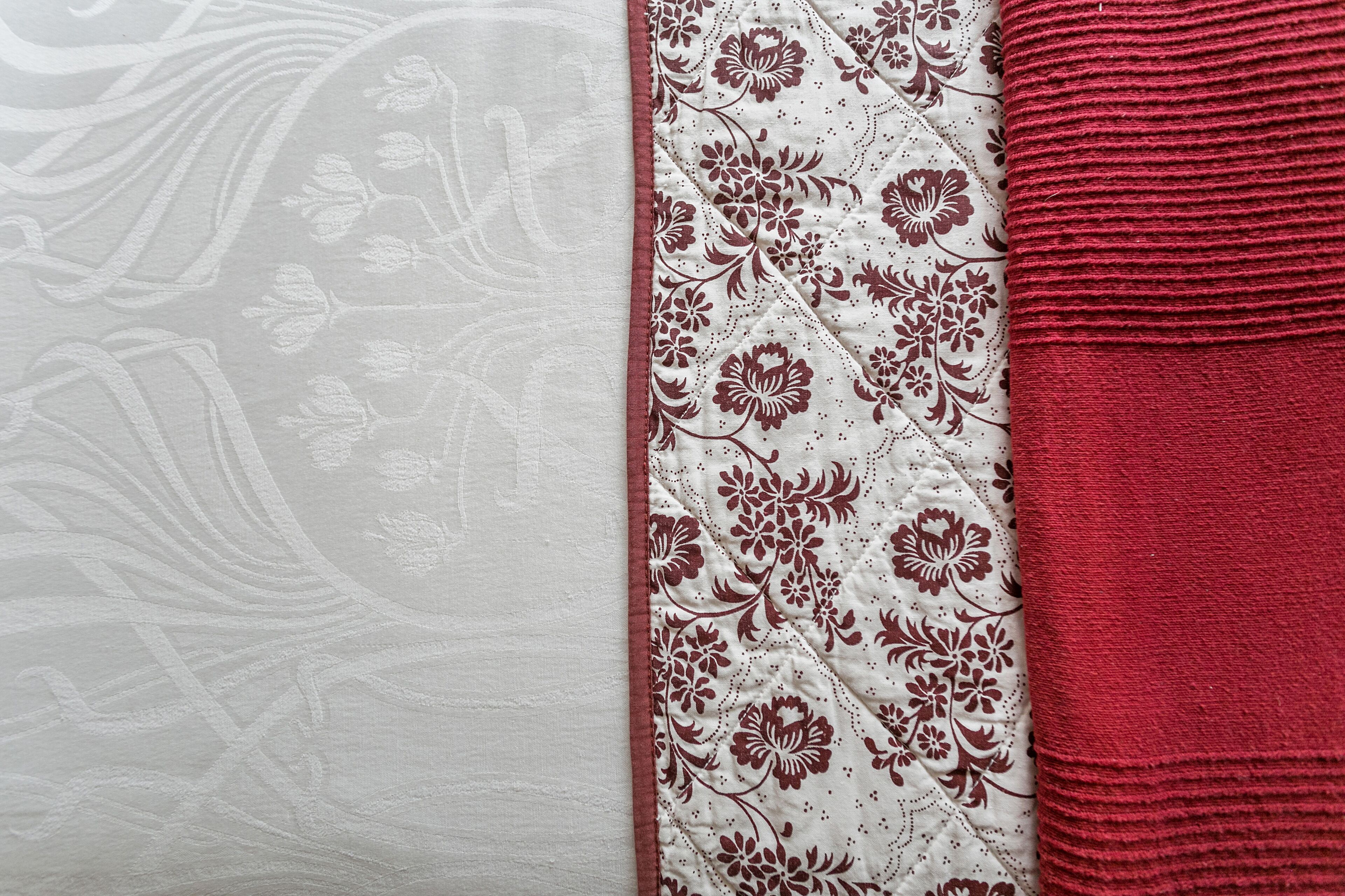 Tejido con estampado floral y borde texturizado rojo.