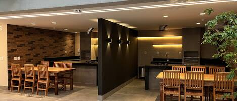 A modern kitchen with a central island, wooden dining table, and chairs.