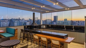 A modern kitchen with a city view, a bar area, and seating. - Life Residence (Belo Horizonte)