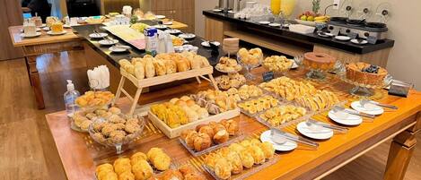 Un bufé con diversos productos horneados y pastelería.