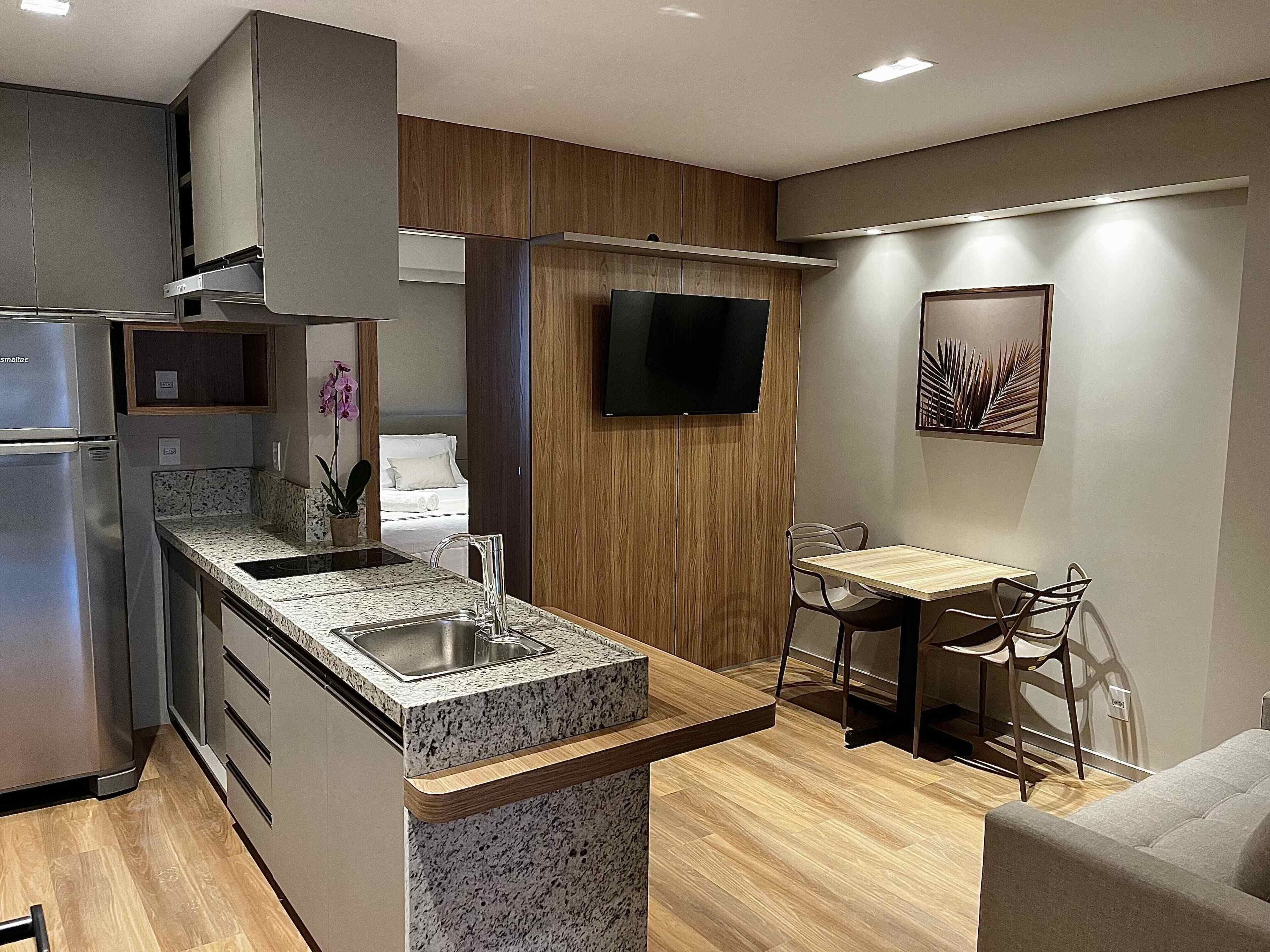 Una cocina moderna con encimeras de granito, horno empotrado y comedor con mesa y sillas.