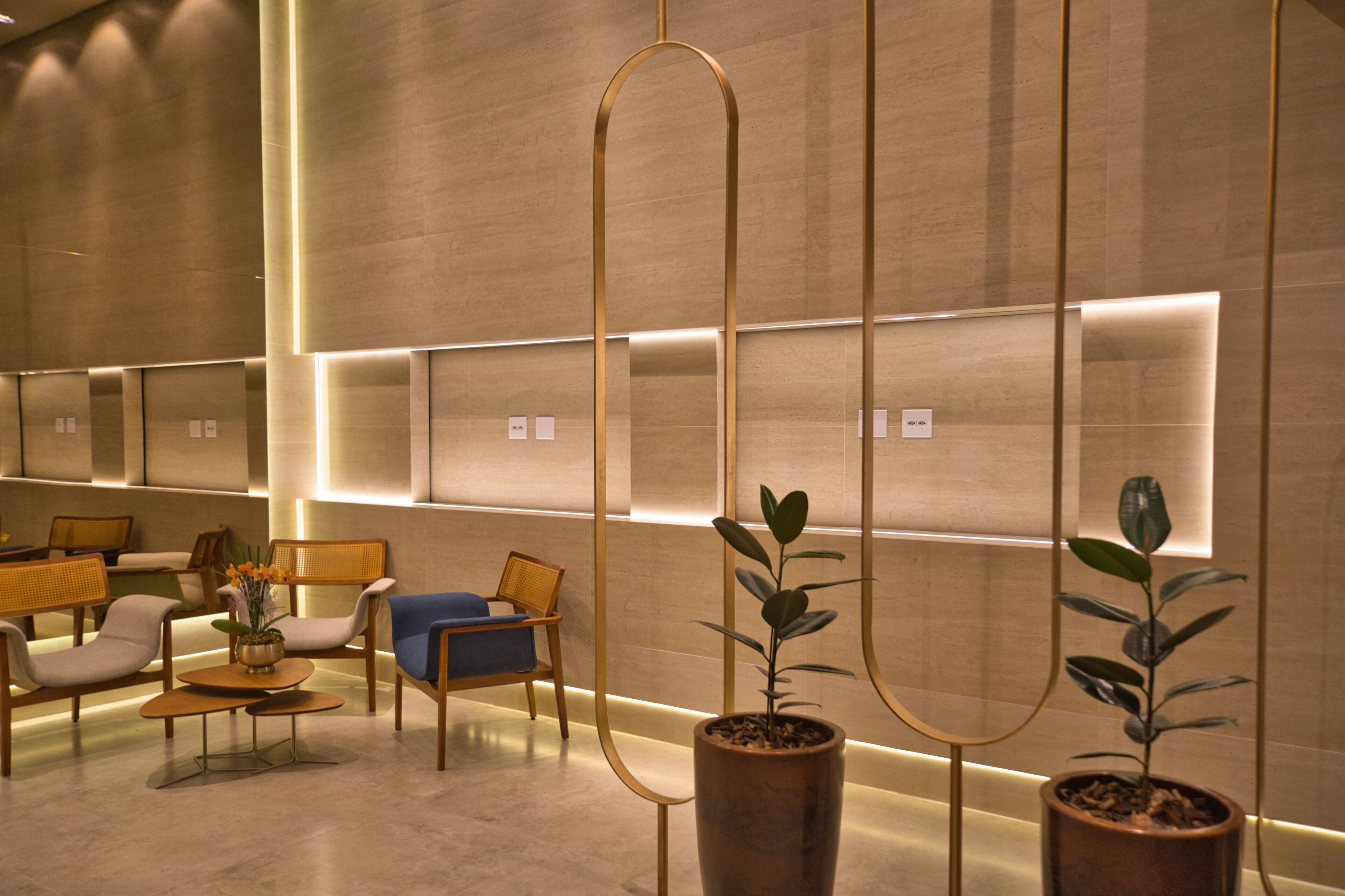 Um hall moderno com assentos, plantas em vasos e painéis de parede iluminados.