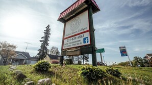 A sign for Hidden Haven Cottages with contact information and amenities like one & two bedroom cottages, kitchens, and free Wi-Fi.