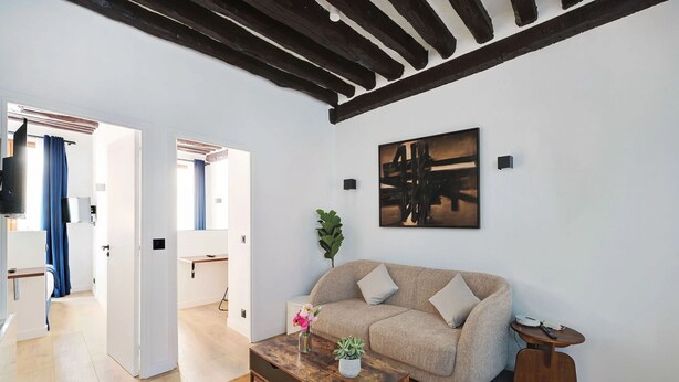 Ein modernes Wohnzimmer mit einer Couch, einem Couchtisch und Kunstwerken an der Wand.