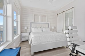 Une chambre à coucher avec un lit, des tables de chevet, un bureau et une chaise.