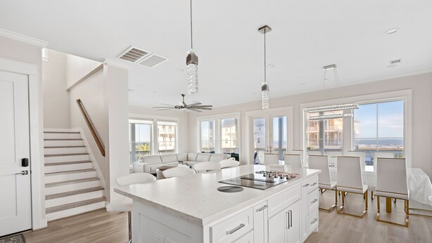 Una cocina moderna con una isla grande, armarios blancos y vistas de la ciudad.